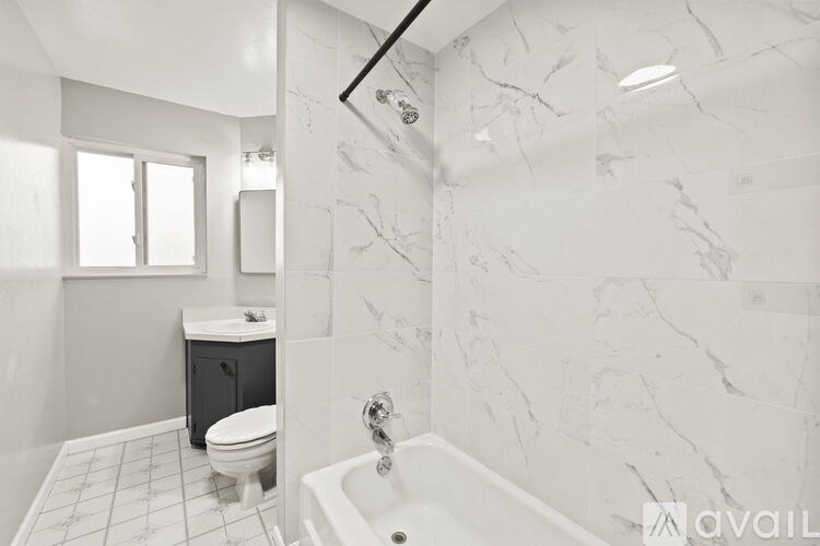 A bathroom with a marble wall and a toilet.