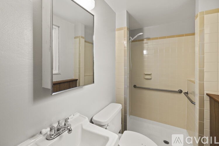A bathroom with a white toilet and a white sink with a mirror above it.