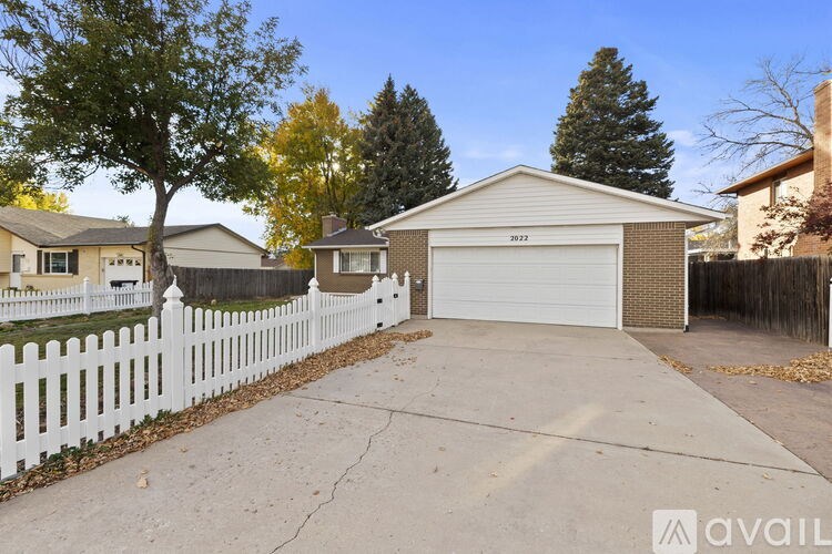 A house with a white fence and a garage door numbered 22172 is available for sale.