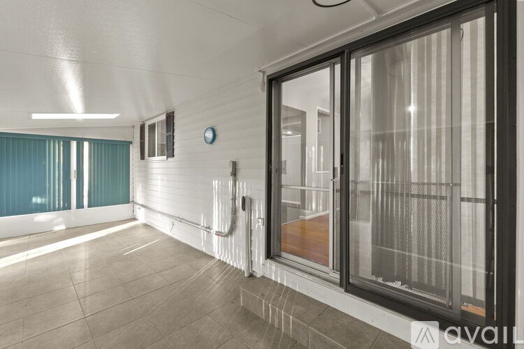 A room with a white ceiling, a clock on the wall, and a glass door.