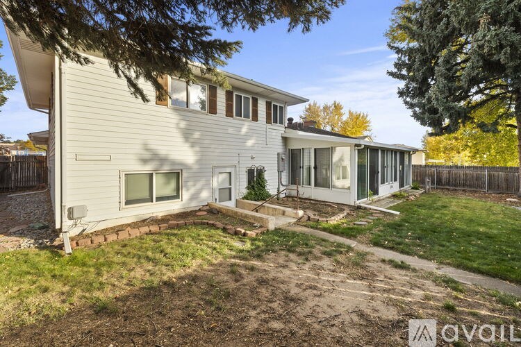 A house with a white exterior and a tree in front of it.