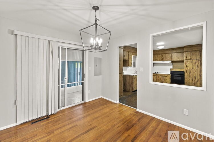 A room with wooden floors and a chandelier hanging from the ceiling.
