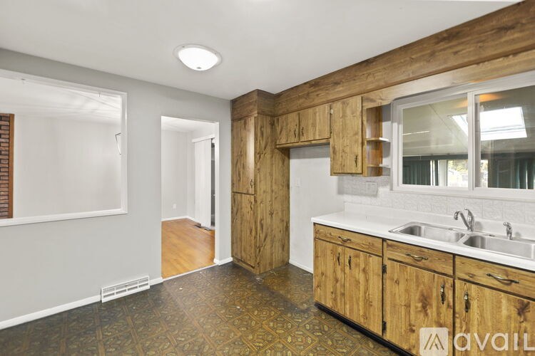 A kitchen with wooden cabinets and a tiled floor.
