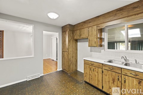 A kitchen with wooden cabinets and a tiled floor.