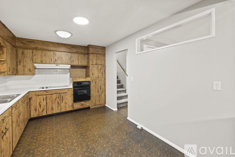 A kitchen with wooden cabinets and a white countertop.