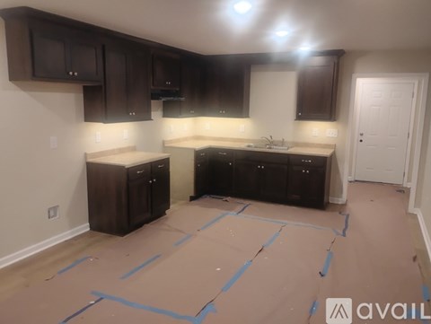 A kitchen with brown cabinets and a countertop is under construction.