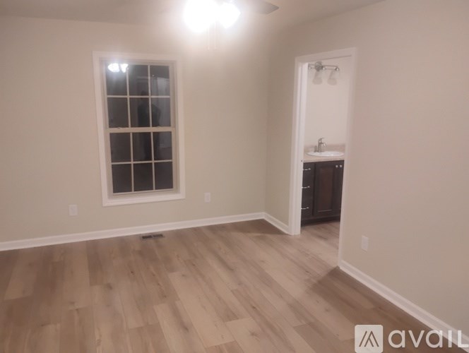 A room with wooden flooring and a window.