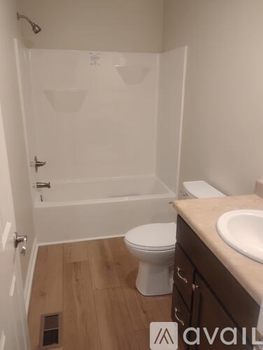 A bathroom with a toilet, sink, and walk-in shower.