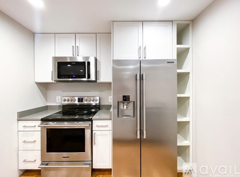 A modern kitchen with a stainless steel refrigerator and oven.