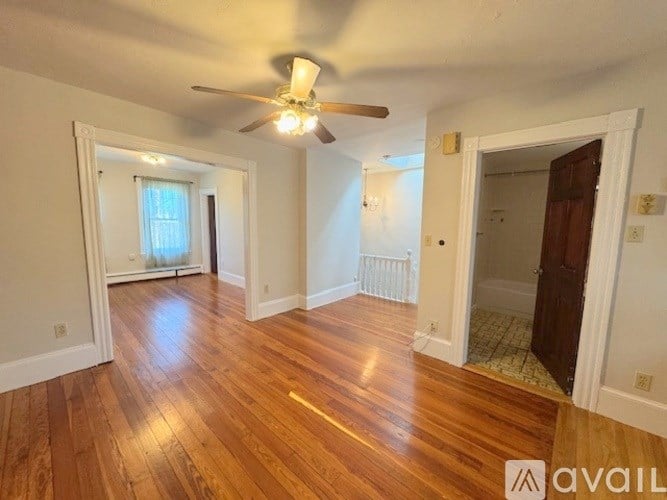 A room with wooden floors and a ceiling fan.