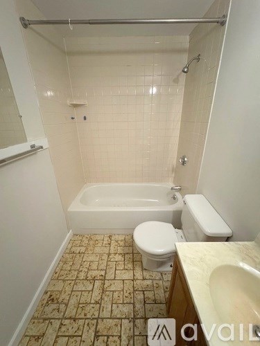 A bathroom with a white toilet, sink, and bathtub.