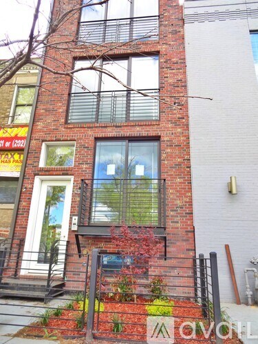 A red brick building with a white door and windows.