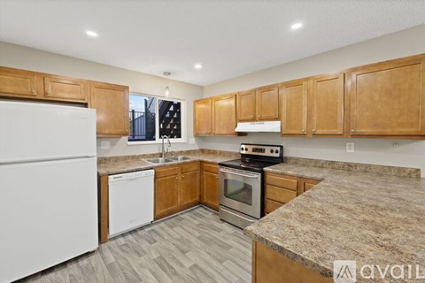 A kitchen with wooden cabinets and a granite countertop.