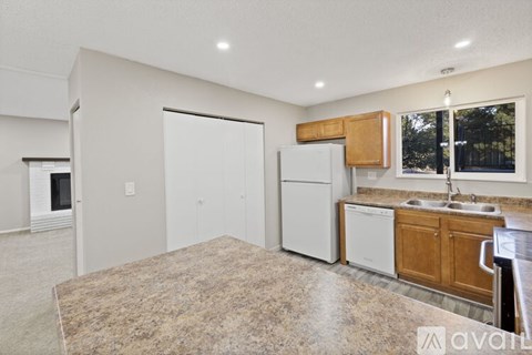 A kitchen with a granite countertop and white appliances.