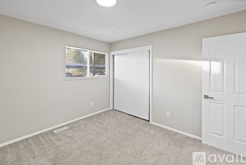A room with a white door and carpeted floor.