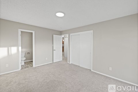 A spacious room with a carpeted floor and white walls.