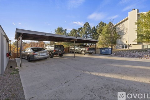 A parking area with a canopy and a car under it.