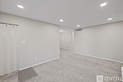 A spacious room with a carpeted floor and a glass door.