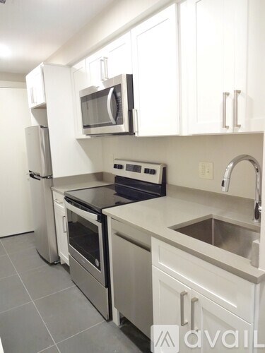 A kitchen with white cabinets and stainless steel appliances.