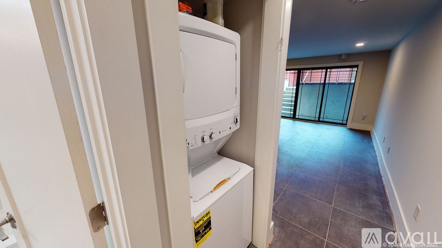 A white dishwasher is in a narrow hallway.
