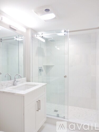 A white bathroom with a glass shower stall.