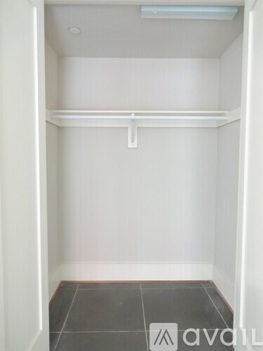 A small, empty room with a white wall and a white door.