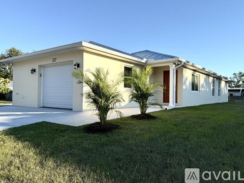 A two-story house with a garage and a driveway.