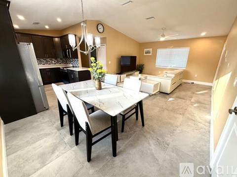 A dining room with a table set for four and a television in the corner.