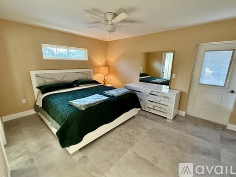 A bedroom with a bed, dresser, and mirror.