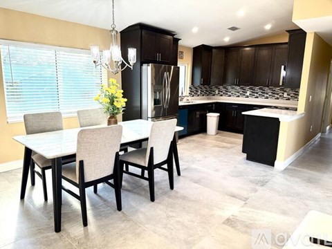 A modern kitchen with a dining table and chairs.