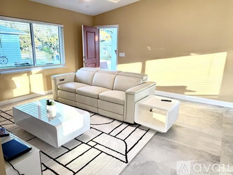 A white sofa with a coffee table in front of it.