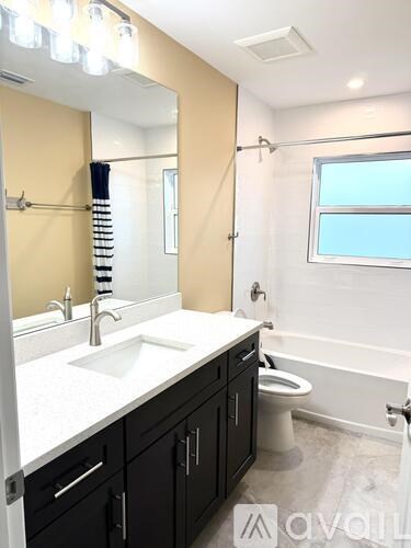 A bathroom with a sink, toilet, and a mirror.