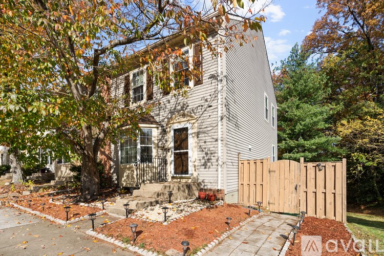 A house with a grey facade and a brown fence.