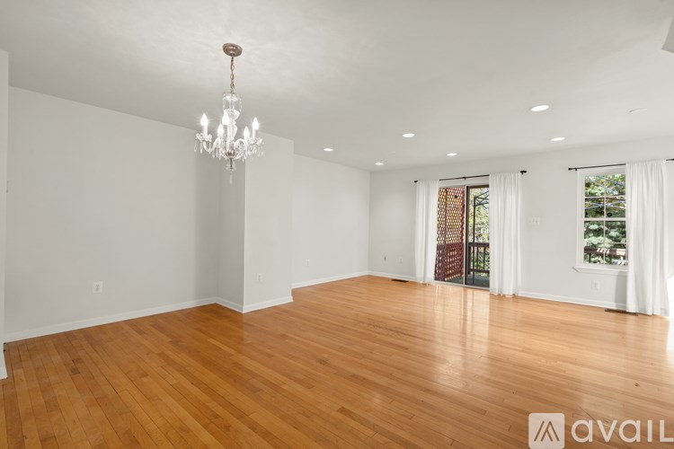 A large empty room with wooden floors and a chandelier.