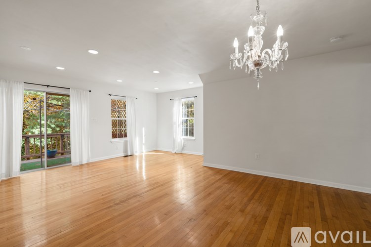 A large empty room with wooden floors and a chandelier.