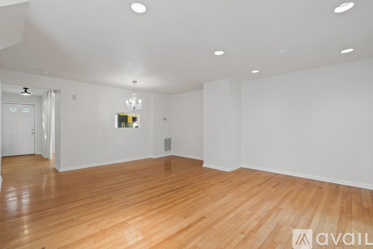 A large empty room with wooden floors and white walls.