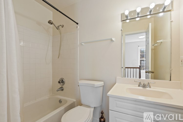 A white bathroom with a toilet, sink, and bathtub.