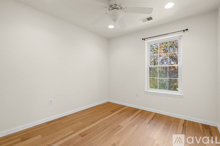 A room with a window and a ceiling fan.