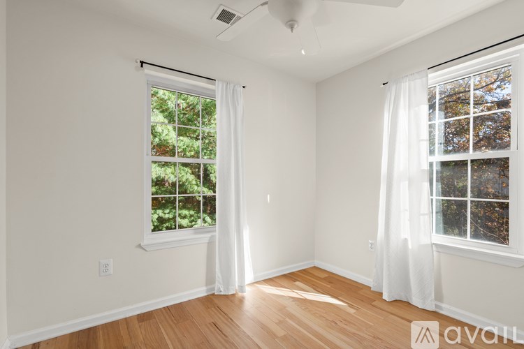 A room with a window and a fan on the ceiling.