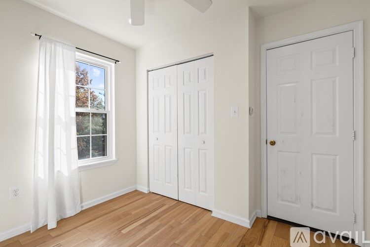 A room with a window, two doors, and a ceiling fan.