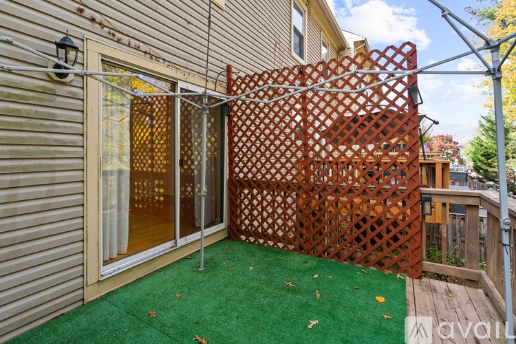 A patio with a green carpet and a lattice fence.