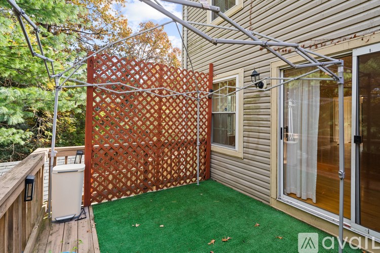 A patio with a lattice fence and a green carpet.