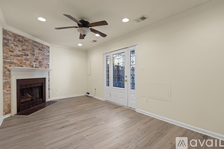 A room with a fireplace and a ceiling fan.