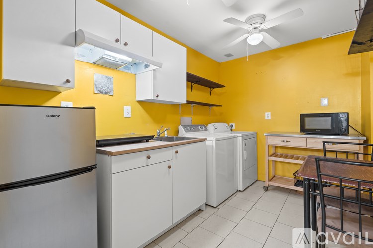 A kitchen with yellow walls and white appliances.