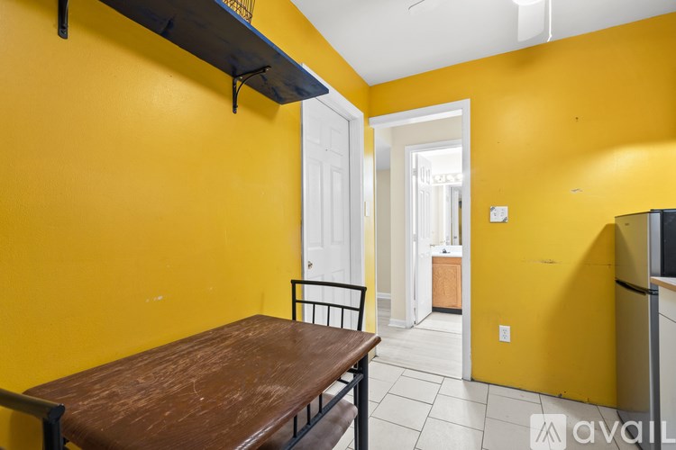A yellow room with a table and chairs.