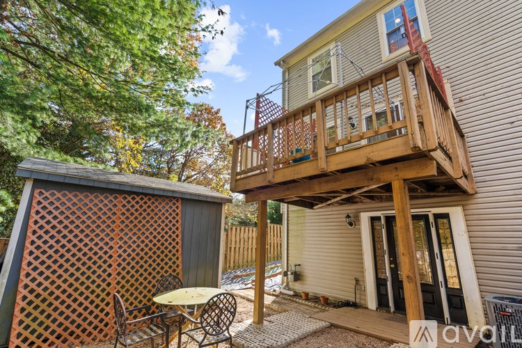 A patio with a table and chairs is attached to a house.