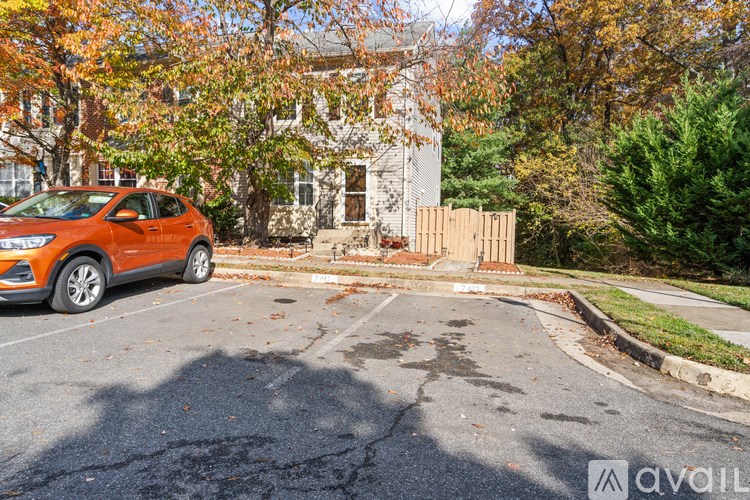 A car is parked in a parking lot in front of a house.