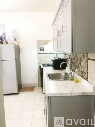 A kitchen with a sink and a fridge.