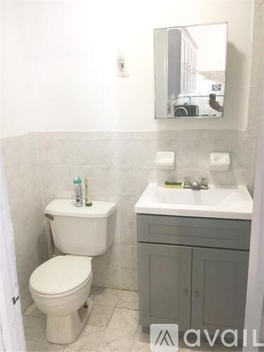 A white toilet sits next to a sink in a bathroom.