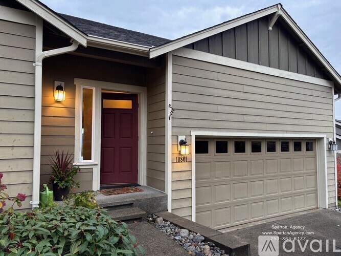 A house with a red door and a garage door is for sale.